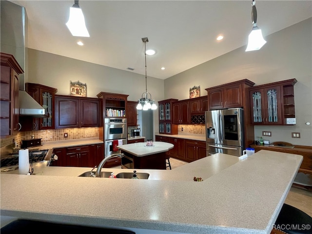 kitchen featuring pendant lighting, a center island, a kitchen bar, and appliances with stainless steel finishes