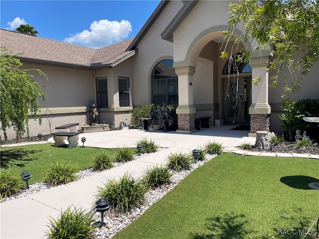 property entrance featuring a lawn