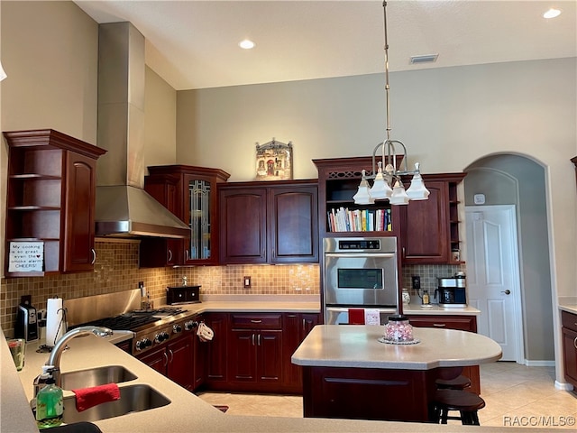 kitchen with sink, a center island, stainless steel appliances, range hood, and pendant lighting