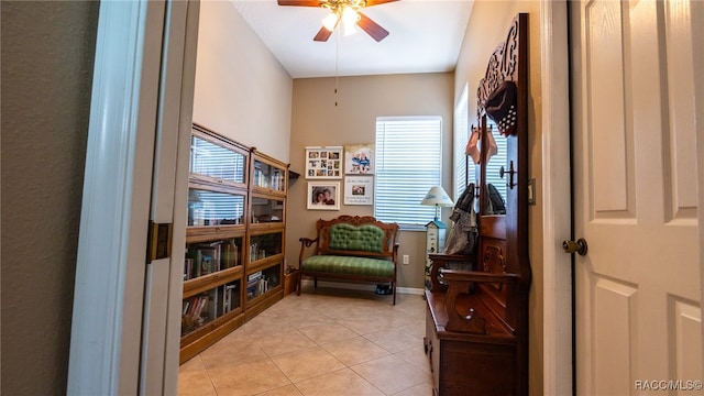 living area with light tile patterned flooring, a wealth of natural light, and ceiling fan