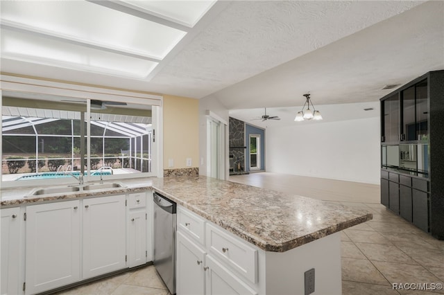 kitchen featuring light tile patterned flooring, ceiling fan, a sink, dishwasher, and a peninsula