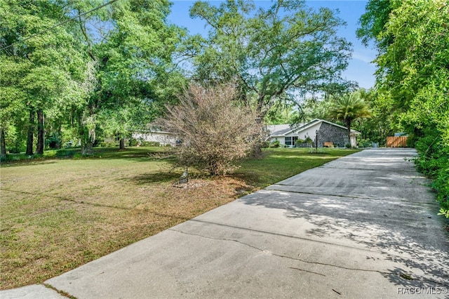 view of property exterior featuring a lawn and driveway