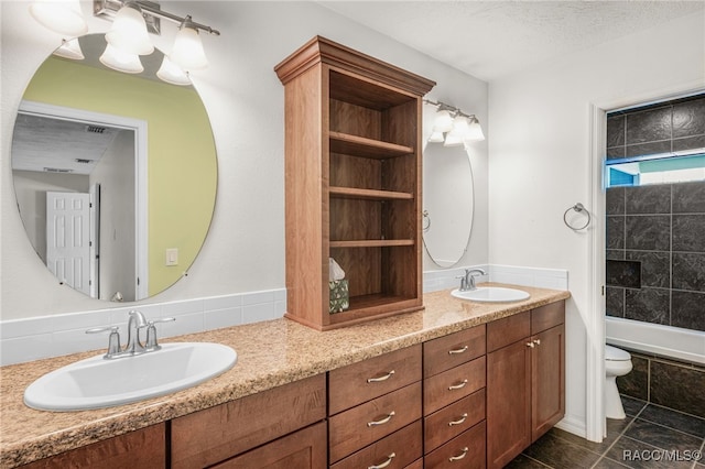 full bathroom featuring double vanity, toilet, and a sink