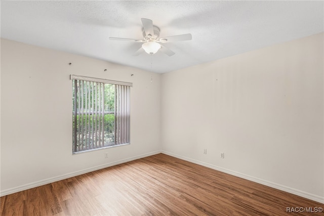 spare room featuring baseboards, a ceiling fan, and wood finished floors