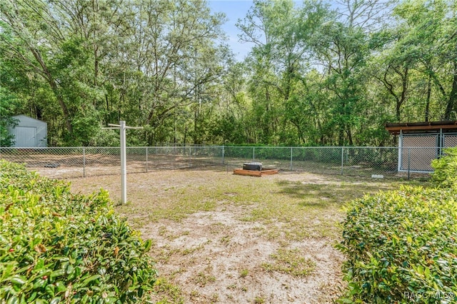 view of yard with fence, an outbuilding, and a shed