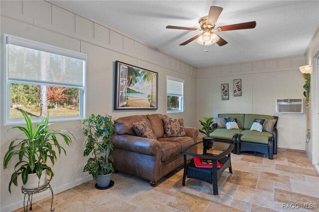 living room featuring ceiling fan and an AC wall unit