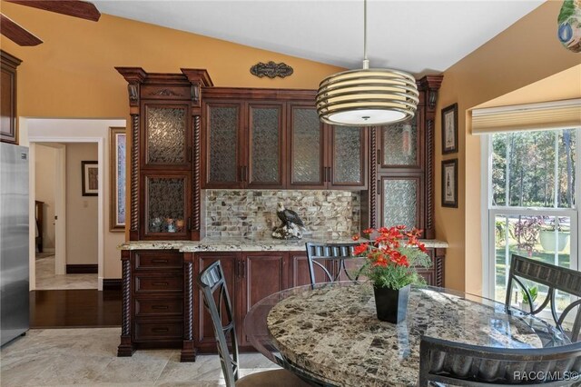 dining room featuring light hardwood / wood-style floors and lofted ceiling