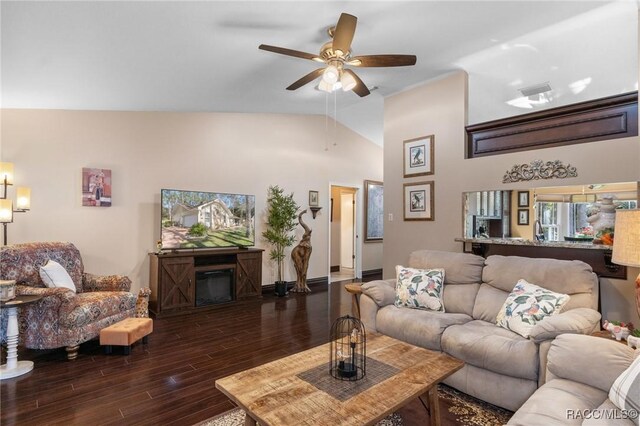 living room with dark hardwood / wood-style floors, ceiling fan, a fireplace, and high vaulted ceiling