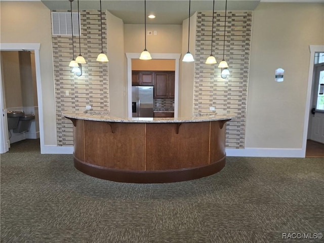 1003 Heron Point Dr, Inverness, FL 34453 - interior space with a kitchen breakfast bar, stainless steel refrigerator with ice dispenser, dark carpet, and visible vents