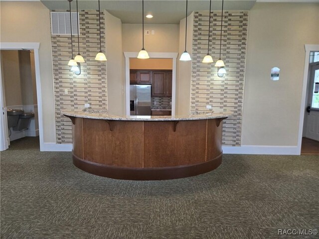 1003 Heron Point Dr, Inverness, FL 34453 - interior space with a kitchen breakfast bar, stainless steel refrigerator with ice dispenser, dark carpet, and visible vents