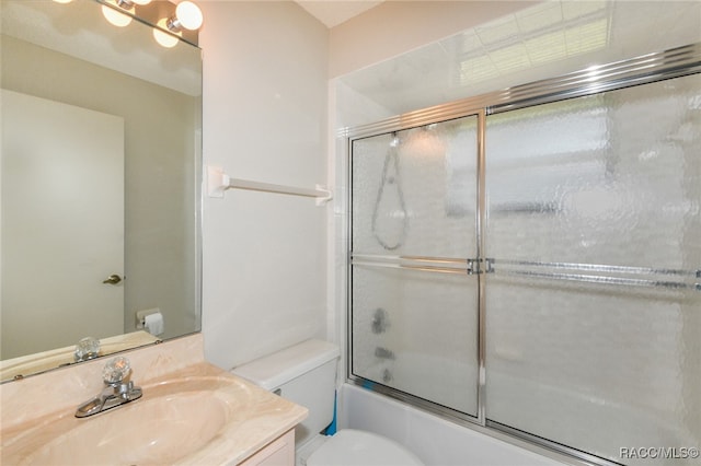 full bathroom with vanity, enclosed tub / shower combo, and toilet