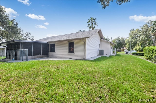 rear view of house featuring a yard, central AC, and a sunroom