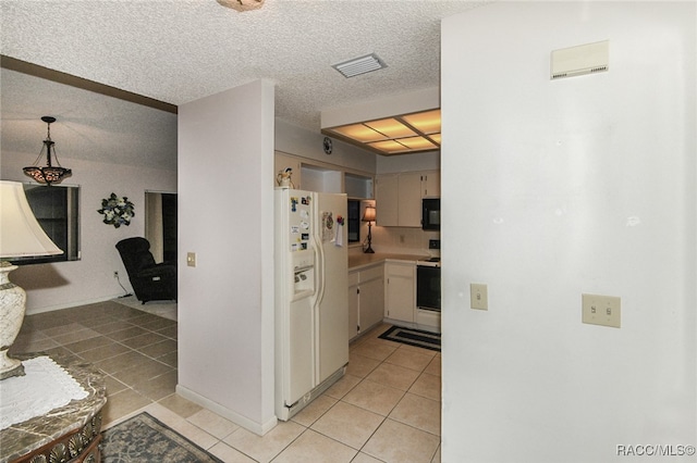 kitchen with white fridge with ice dispenser, light tile patterned floors, hanging light fixtures, and range