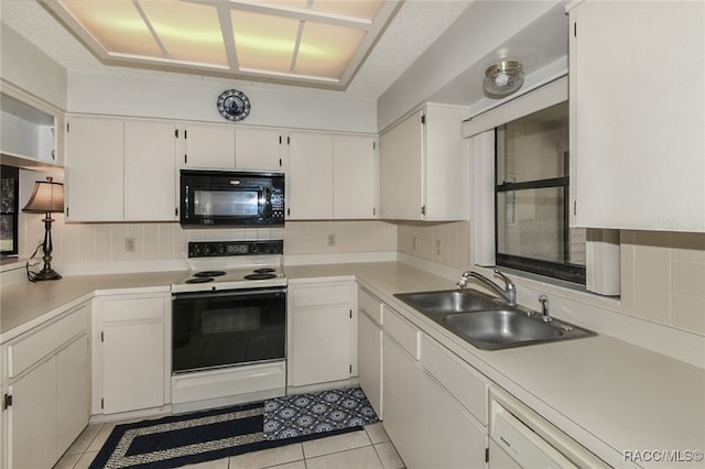 kitchen with sink, electric range, tasteful backsplash, light tile patterned flooring, and white cabinetry