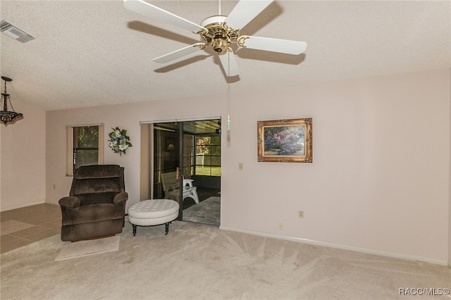 sitting room featuring a textured ceiling, ceiling fan, and light carpet