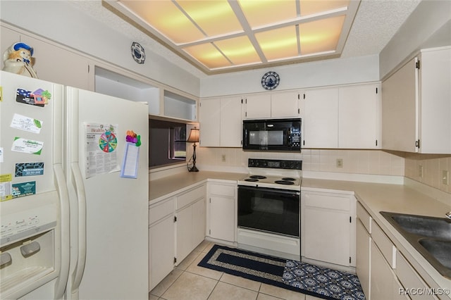 kitchen featuring decorative backsplash, white appliances, sink, white cabinets, and light tile patterned flooring