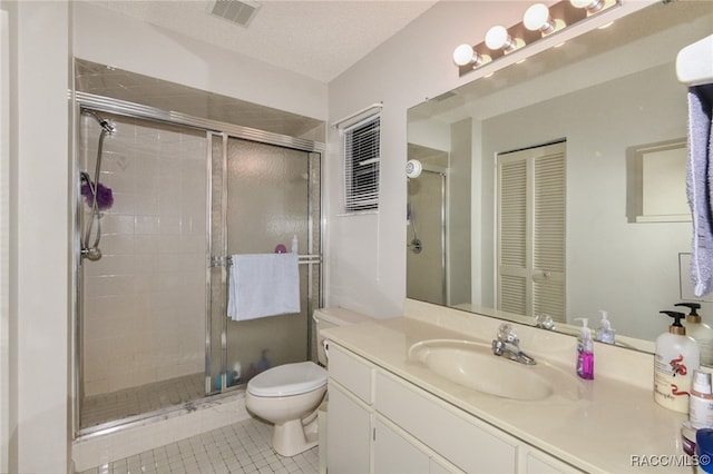 bathroom featuring tile patterned flooring, vanity, toilet, and walk in shower