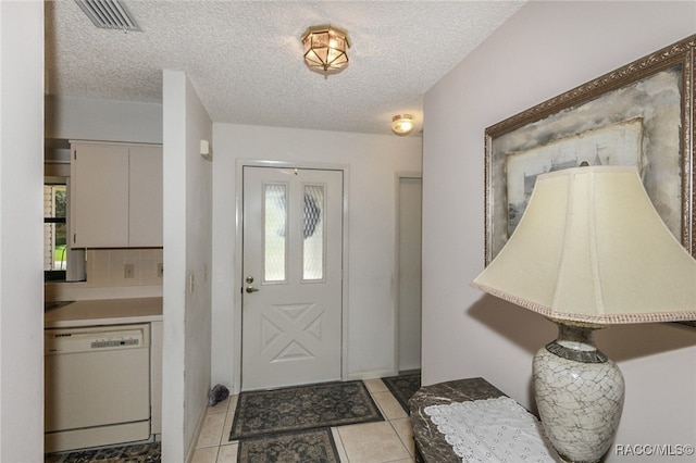 foyer with light tile patterned floors, a healthy amount of sunlight, and a textured ceiling