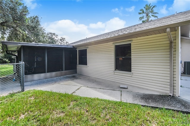 rear view of property featuring a sunroom, cooling unit, a yard, and a patio