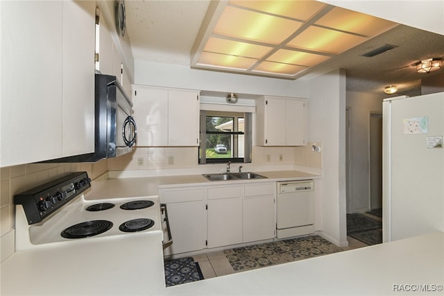 kitchen with tasteful backsplash, white cabinets, and white appliances