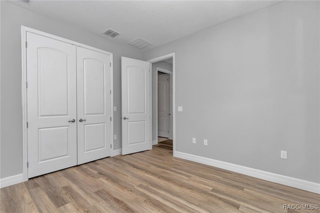 7024 N Fountainhead Dr, Citrus Springs, FL 34433 - unfurnished bedroom with light wood-type flooring and a closet