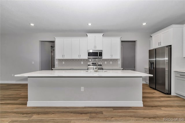 7024 N Fountainhead Dr, Citrus Springs, FL 34433 - kitchen with stainless steel appliances, a center island with sink, decorative backsplash, light stone countertops, and recessed lighting