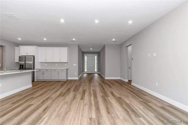 7024 N Fountainhead Dr, Citrus Springs, FL 34433 - unfurnished living room with light wood-type flooring and recessed lighting