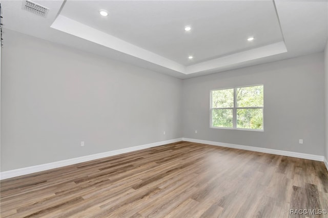 7024 N Fountainhead Dr, Citrus Springs, FL 34433 - unfurnished room featuring a tray ceiling, wood finished floors, and recessed lighting