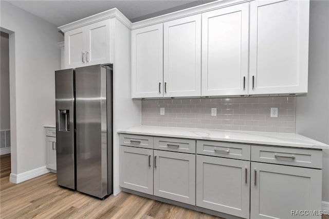 7024 N Fountainhead Dr, Citrus Springs, FL 34433 - kitchen with stainless steel fridge, light wood-type flooring, decorative backsplash, and gray cabinets
