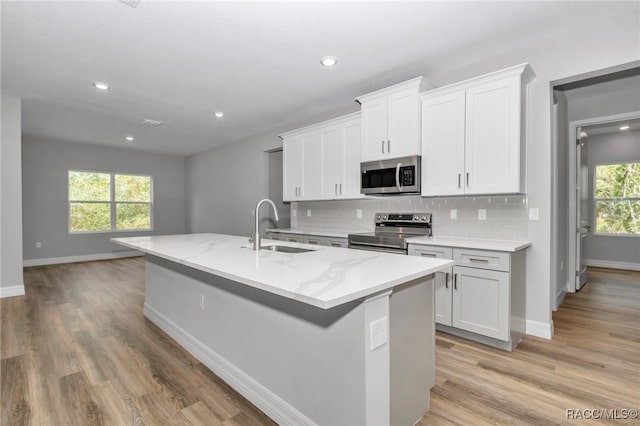 7024 N Fountainhead Dr, Citrus Springs, FL 34433 - kitchen with stainless steel appliances, light wood finished floors, tasteful backsplash, plenty of natural light, and recessed lighting