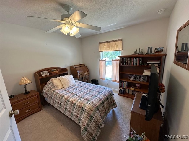 bedroom featuring a textured ceiling, ceiling fan, and carpet