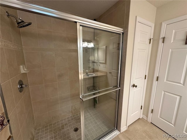 full bathroom with a shower stall and tile patterned floors