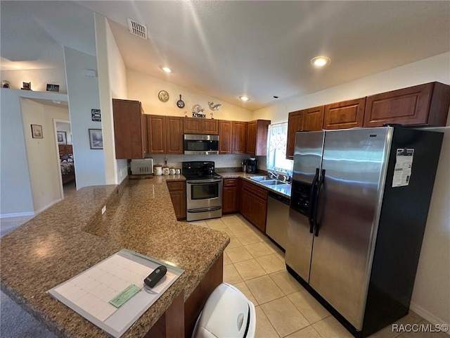 kitchen with a peninsula, vaulted ceiling, visible vents, a sink, and stainless steel appliances