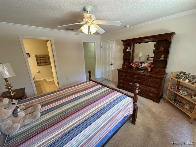 bedroom with ensuite bath, visible vents, a textured ceiling, and light colored carpet