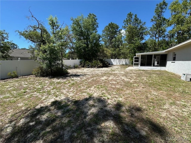 view of yard featuring a fenced backyard and a sunroom