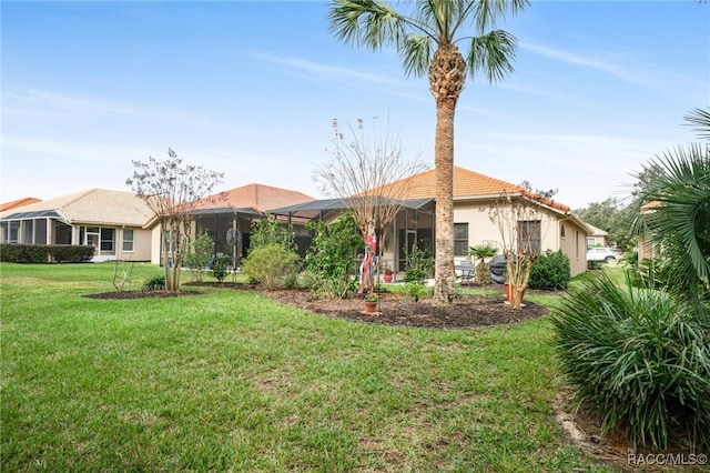 back of property featuring a lanai and a yard