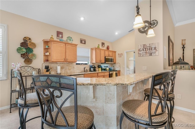 kitchen with decorative backsplash, light stone countertops, stainless steel appliances, sink, and pendant lighting