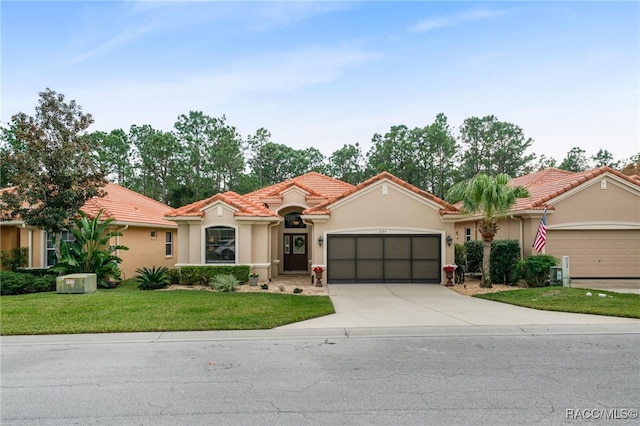 mediterranean / spanish-style home with a garage and a front lawn