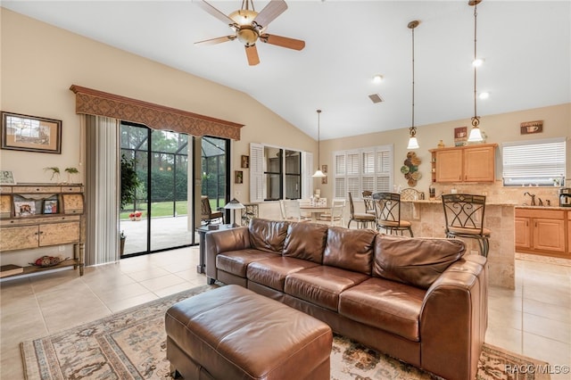 living room featuring ceiling fan, light tile patterned floors, sink, and vaulted ceiling