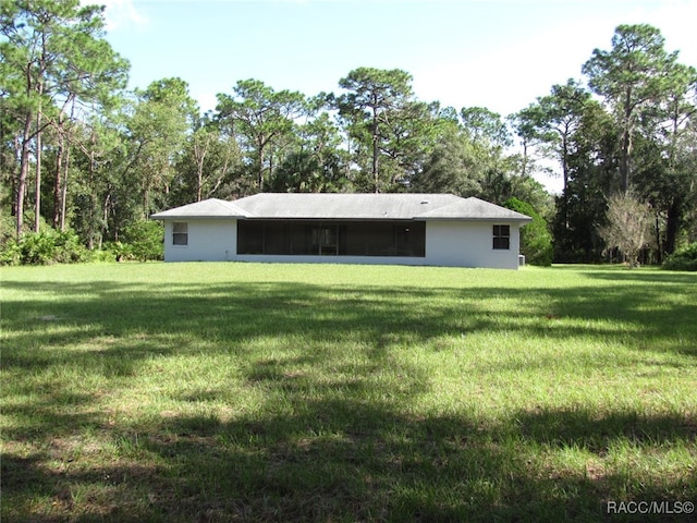 back of property with a yard and a sunroom