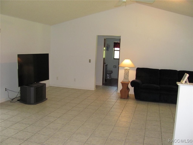 living room with ceiling fan, light tile patterned floors, and vaulted ceiling