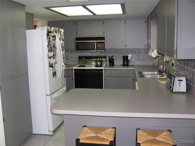 kitchen featuring tasteful backsplash, sink, electric range, kitchen peninsula, and white refrigerator