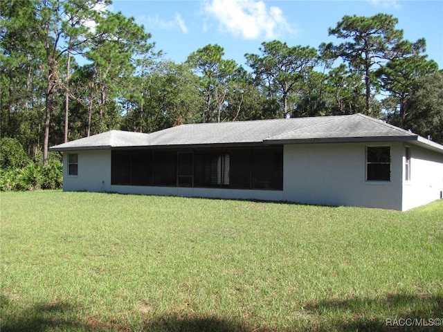 back of property with a yard and a sunroom