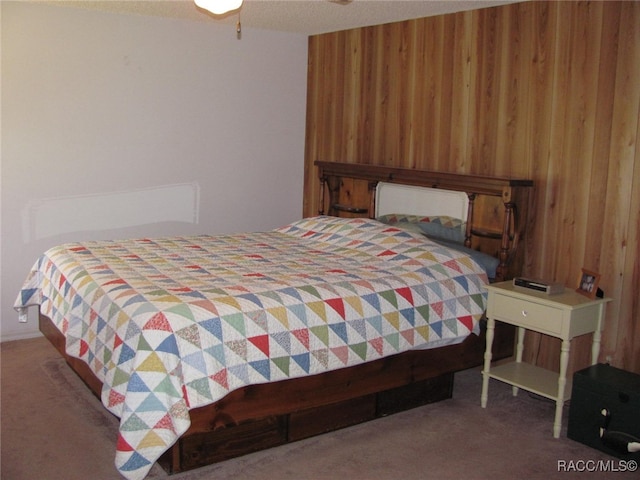 bedroom with wood walls and carpet flooring