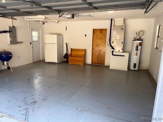 garage featuring a garage door opener, electric panel, heating unit, electric water heater, and white fridge