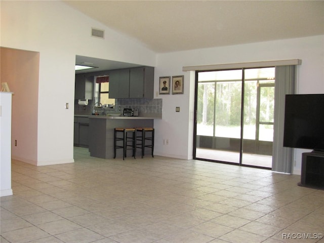 unfurnished living room featuring light tile patterned floors and vaulted ceiling