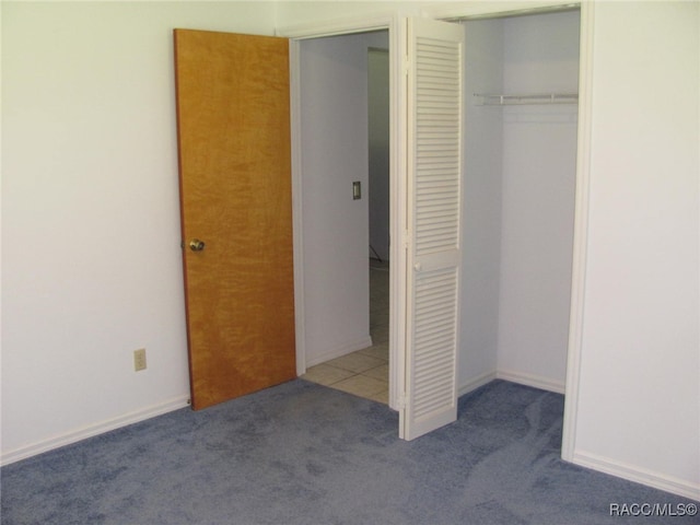 unfurnished bedroom featuring a closet and light carpet