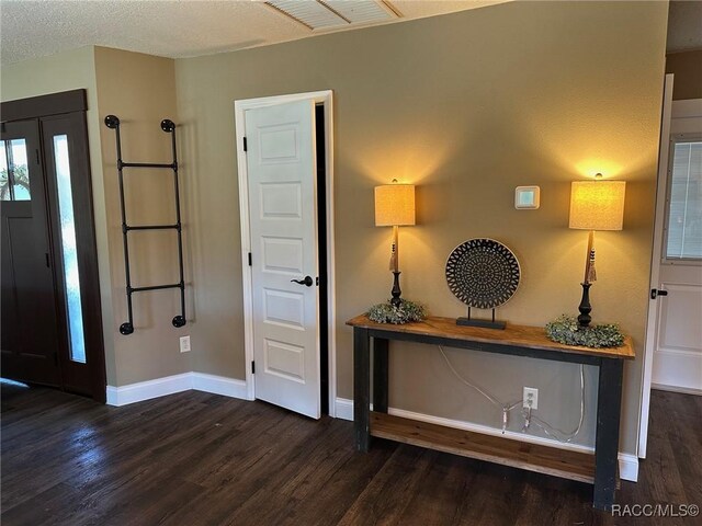 unfurnished living room with ceiling fan, a fireplace, dark wood-type flooring, and a textured ceiling