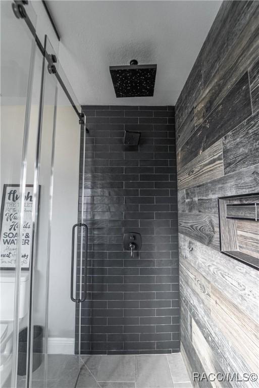 bathroom featuring a shower with door and tile patterned flooring