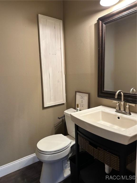 bathroom featuring vanity, toilet, and wood-type flooring